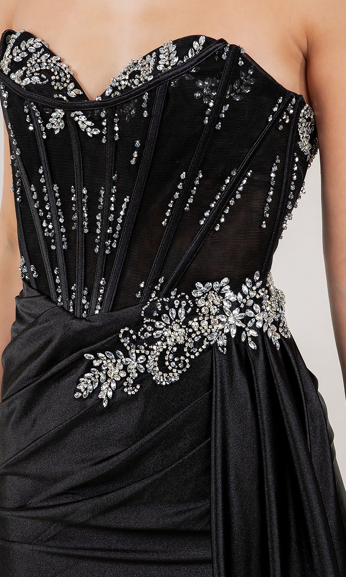 A close-up of the Cinderella Couture 8511J long prom dress, featuring a strapless black design with sheer panels, crystal beadwork, and large rhinestone accents at the waist and bodice.